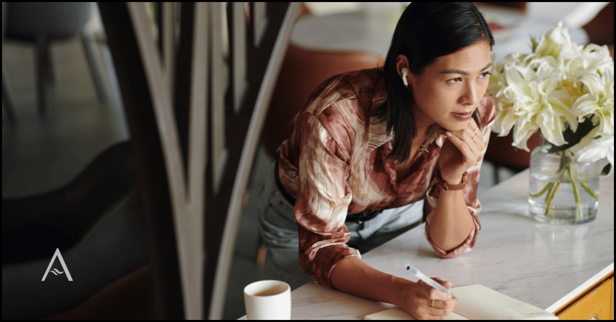 Thoughtful female business owner reviewing notes at a desk, representing a founder experiencing decision fatigue and signs she has outgrown her marketing.